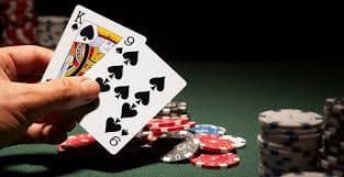 Dealer live casino memandu taruhan roulette dengan meja berlampu hijau terang